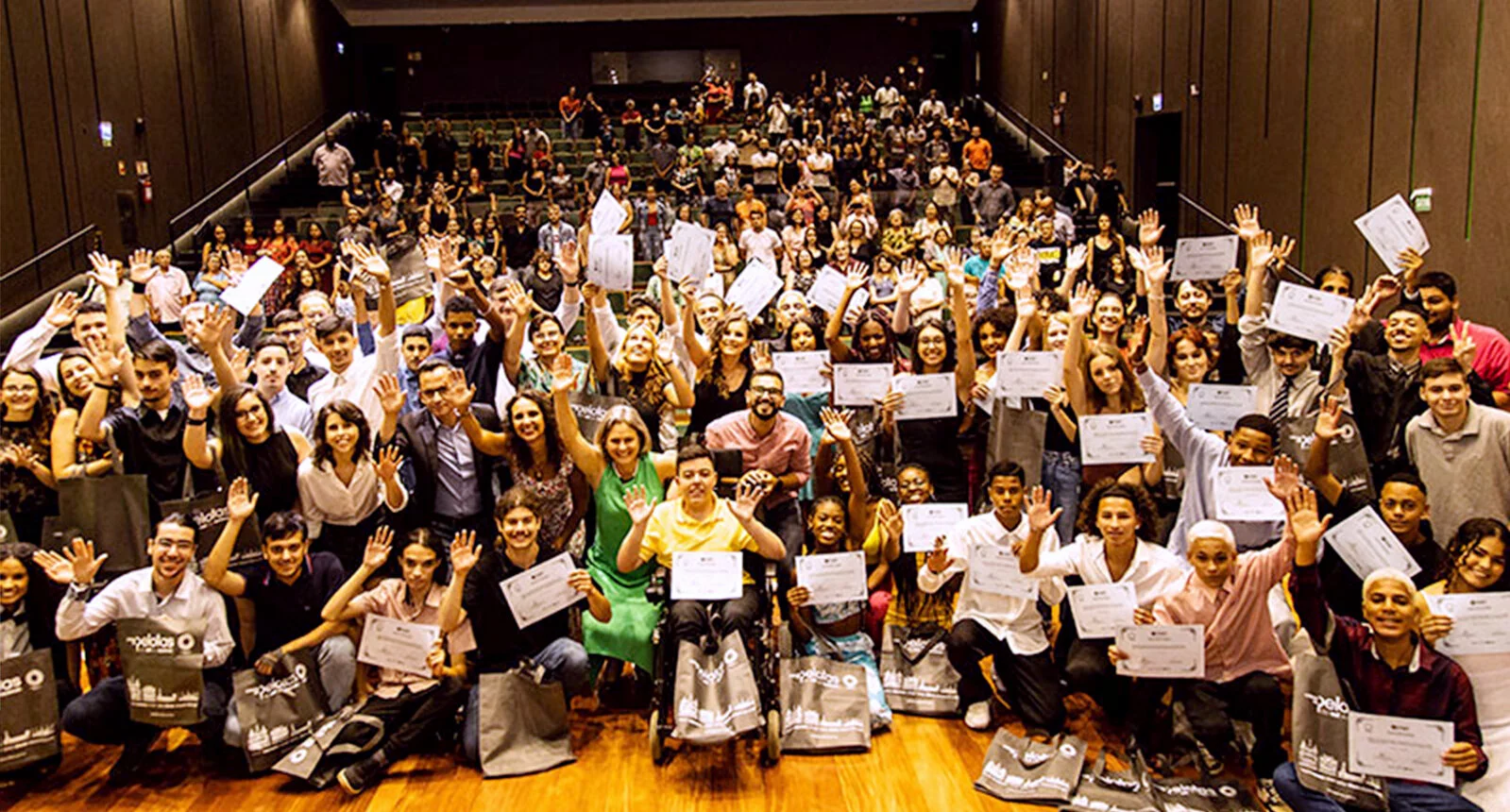 A crowd of people posing for a photo with certificates and happy faces at Graduation Job Market Training Youth START - Pacto Pelotas Pela Paz