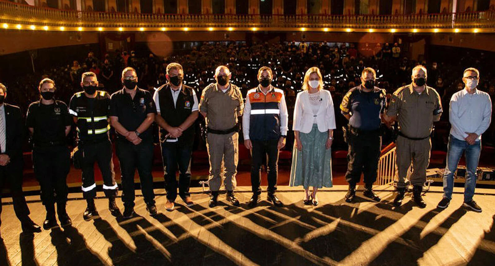 Police Forces Leadership members on stage together, all wearing masks- Pacto Pelotas Pela Paz -