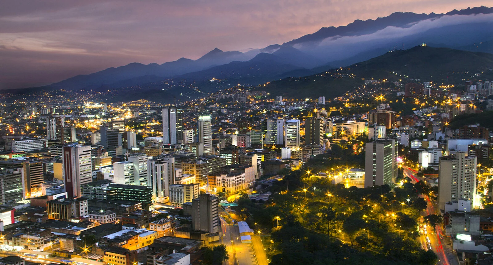 Panoramic view of Santiago del Cali at night featuring buildings and beautiful mountains in the background