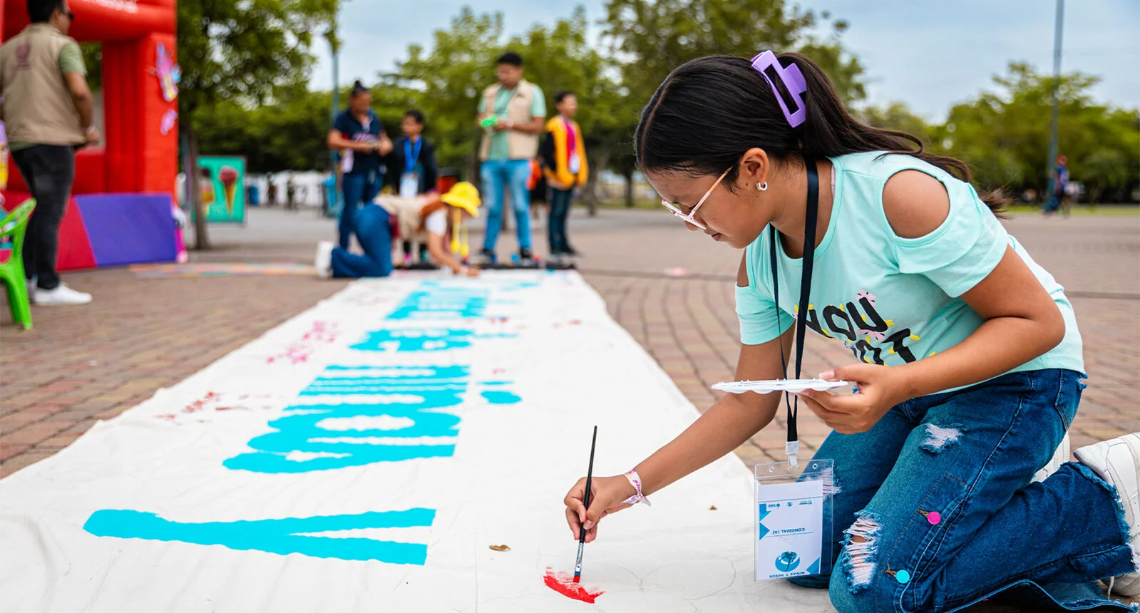 Young girl painting on a banner