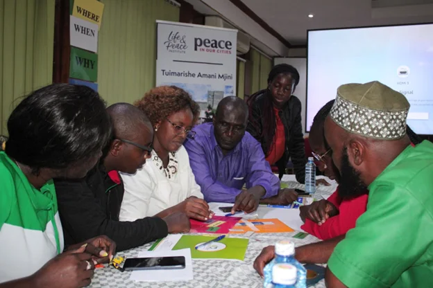 A group gathers in conversation at a Life & Peace Institute event in Kenya.